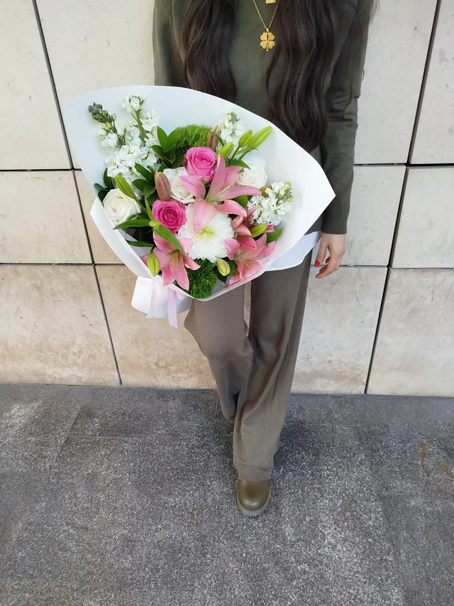 Pembe lilyum ve güllerle hazırlanan beyaz ambalajlı buket
